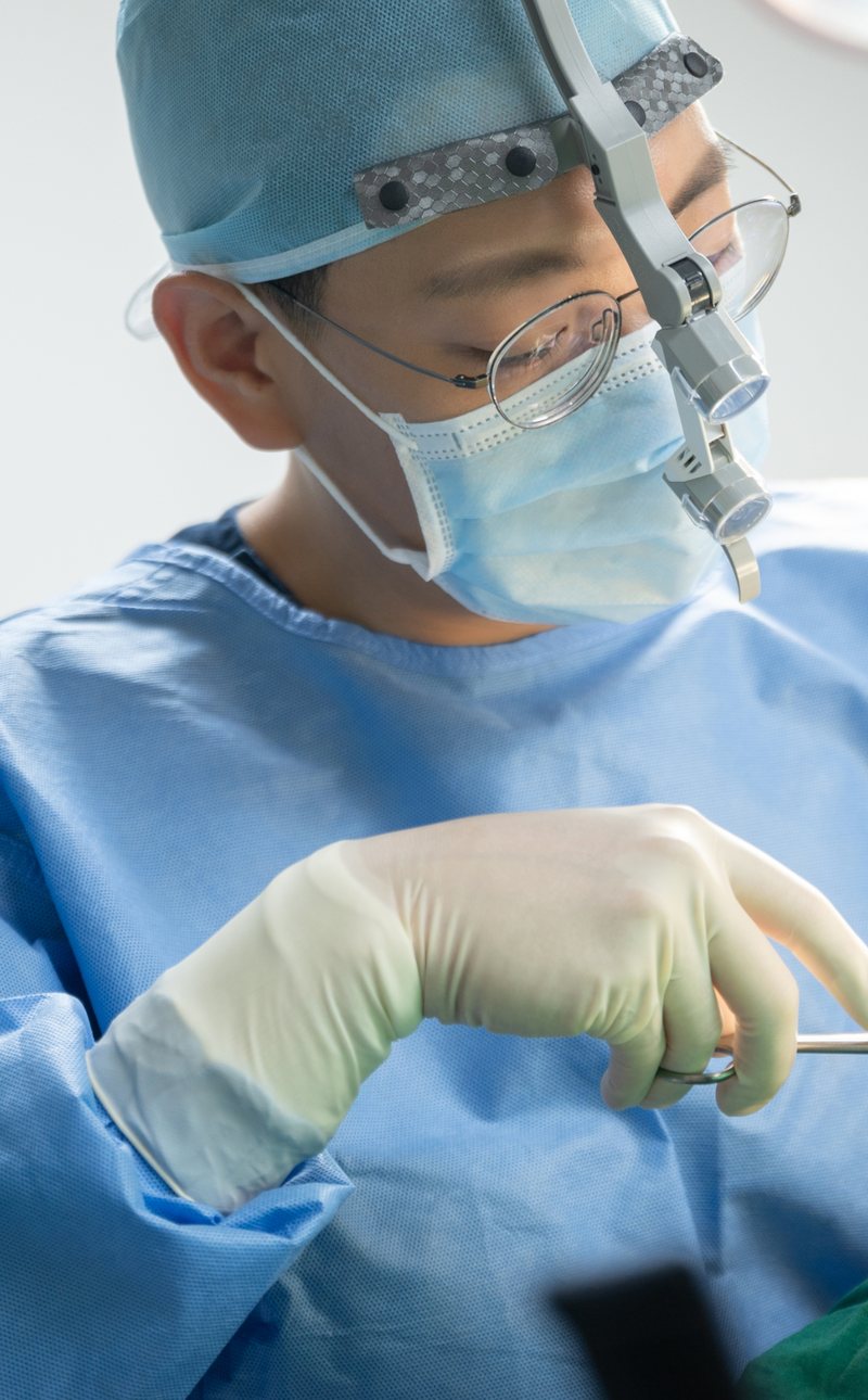 手術用ルーペを着け、手術台に向かう院長の横顔